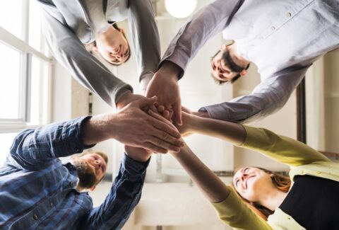 low-angle-view-businesspeople-stacking-hand-together-workplace